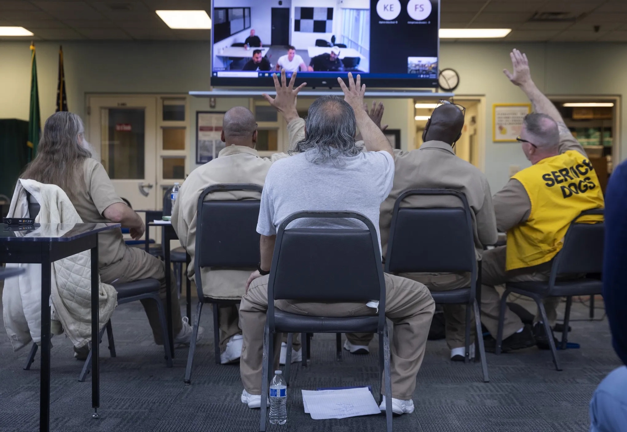 Men incarcerated at Stafford Creek Corrections Center in Aberdeen wave goodbye as a counterpart at Norway’s Romerike prison leaves a video call. A group from each prison speaks once a month to talk about their lives and conditions in their respective prisons. (Ellen M. Banner / The Seattle Times)