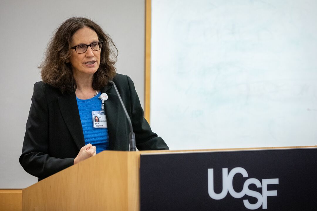 Dr. Alicia Fernandez presenting at a UCSF lectern. 